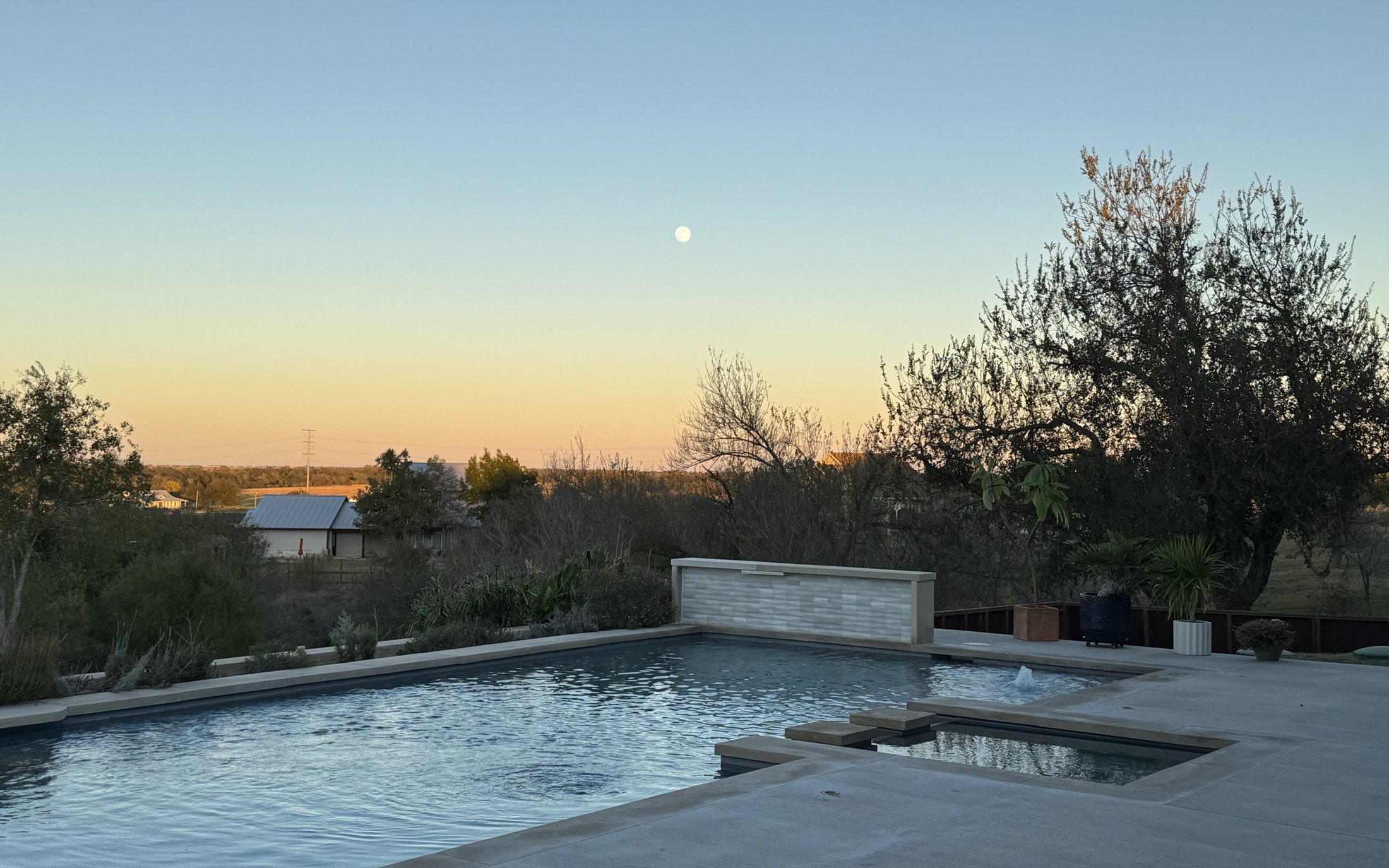 Custom residential pool and spa lit at dusk