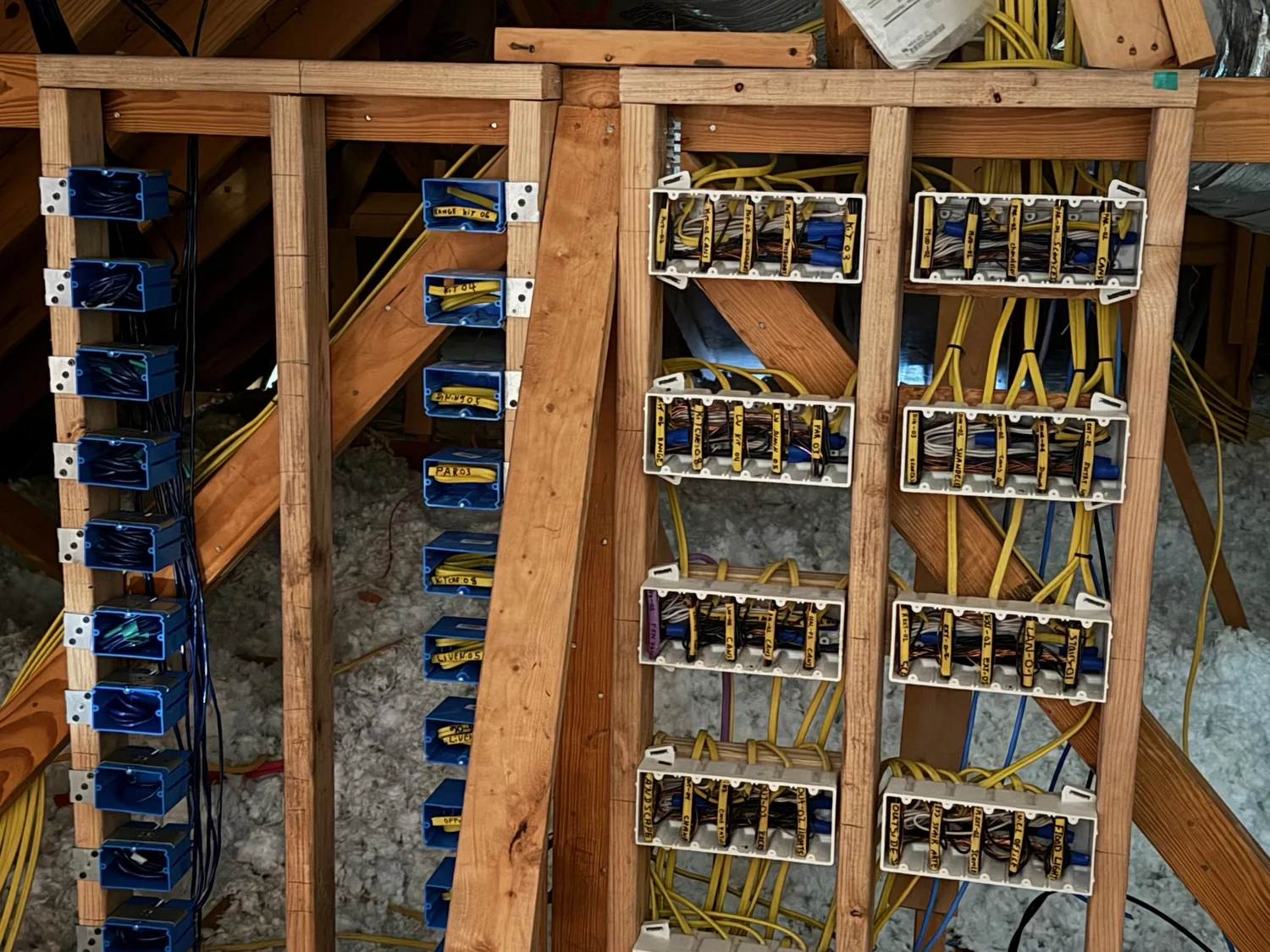 Labeled junction boxes and wiring in wall framing on a DAS Electric job