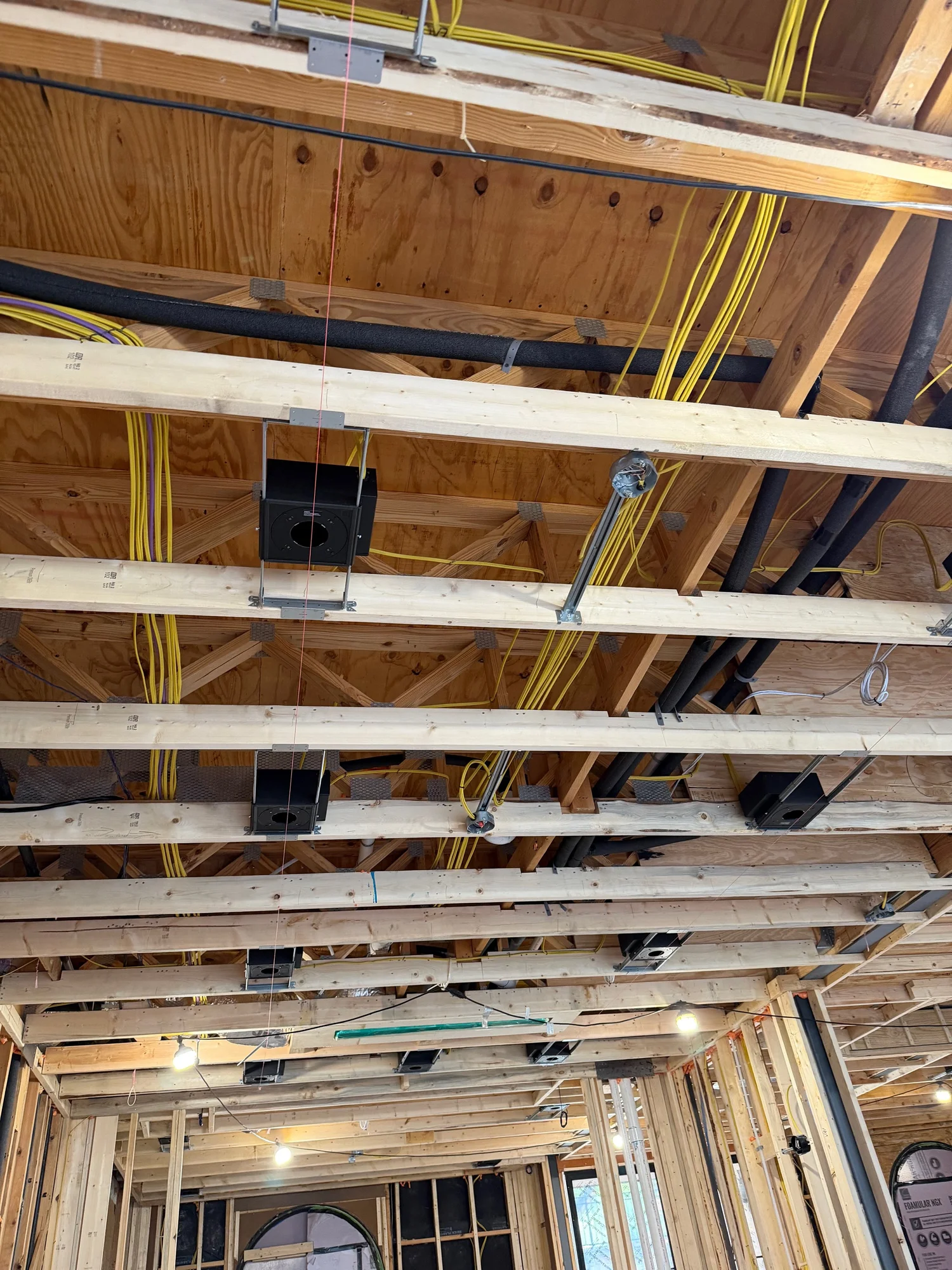 Residential rough-in with speaker and lighting boxes in ceiling framing